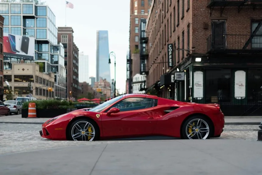 A red ferrari parked by the road. Ferraris are among the top most valuable cars 860x574.jpg